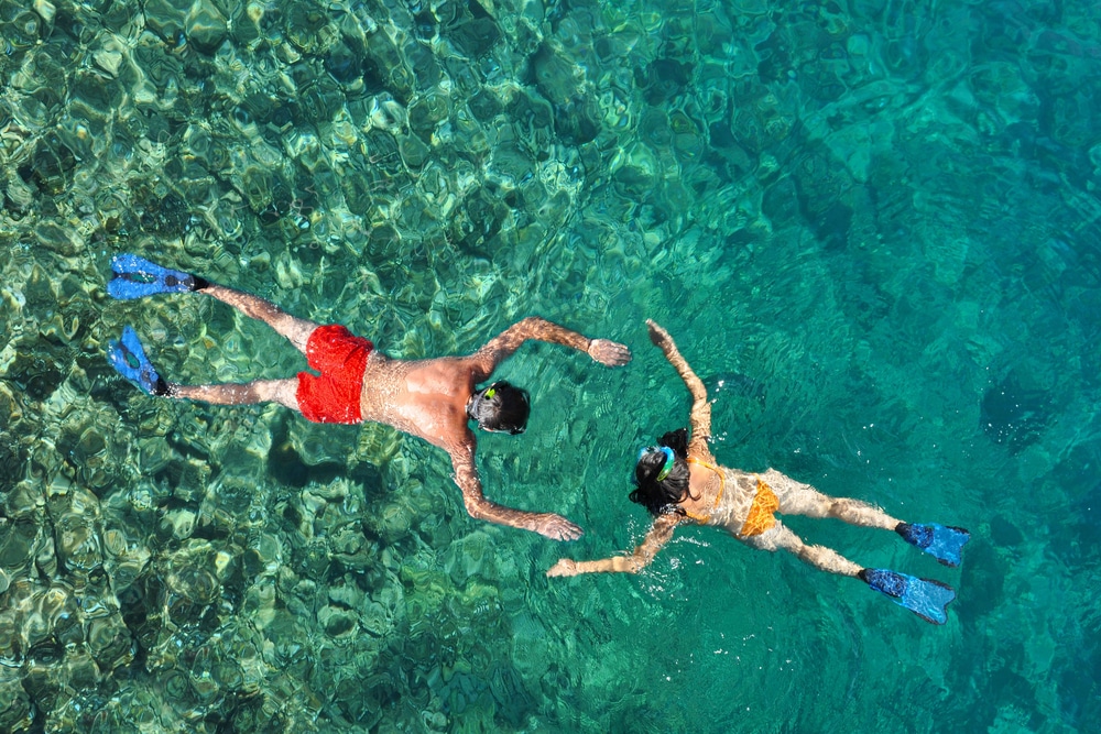 two people snorkeling in the waters of the phi phi islands