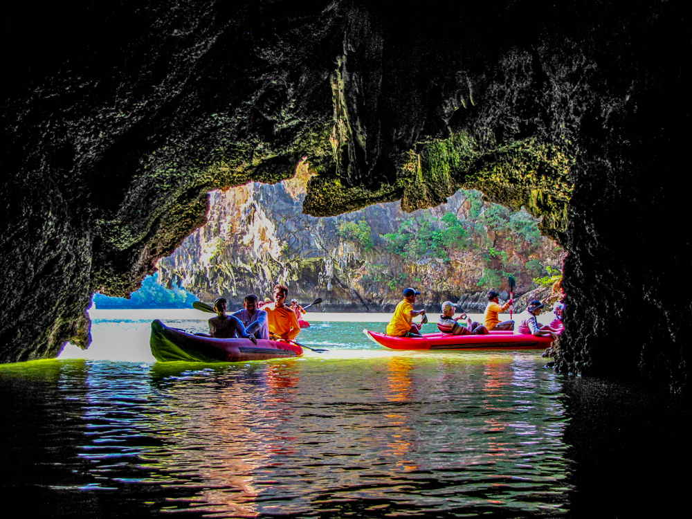 a group of kayakers exploring phang nga bay's famous caves in groups of two