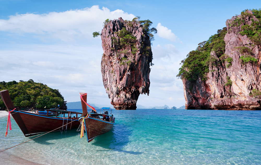 the limestone cliff that adorns the beautiful james bond island as seen from a longtail boat