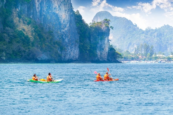 two kayaks, one red and one yellow, glide through the open waters in the Phi phi islands 