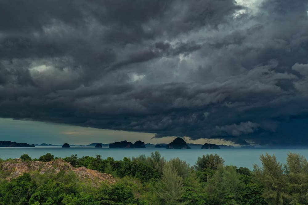 dark, stormy clouds gather above the blue waters of the andaman sea in Phuket