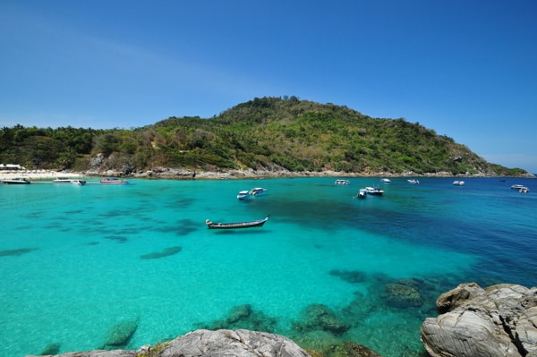 raya island as seen from the nearby hills with people swimming amongst the serene clear waters below