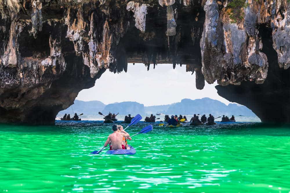 Kayakers exploring the caves at Phang Nga Bay while on a speedboat tour of the region